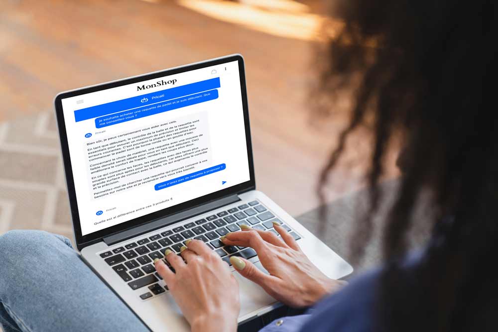 Personne utilisant un assistant conversationnel sur un ordinateur portable.